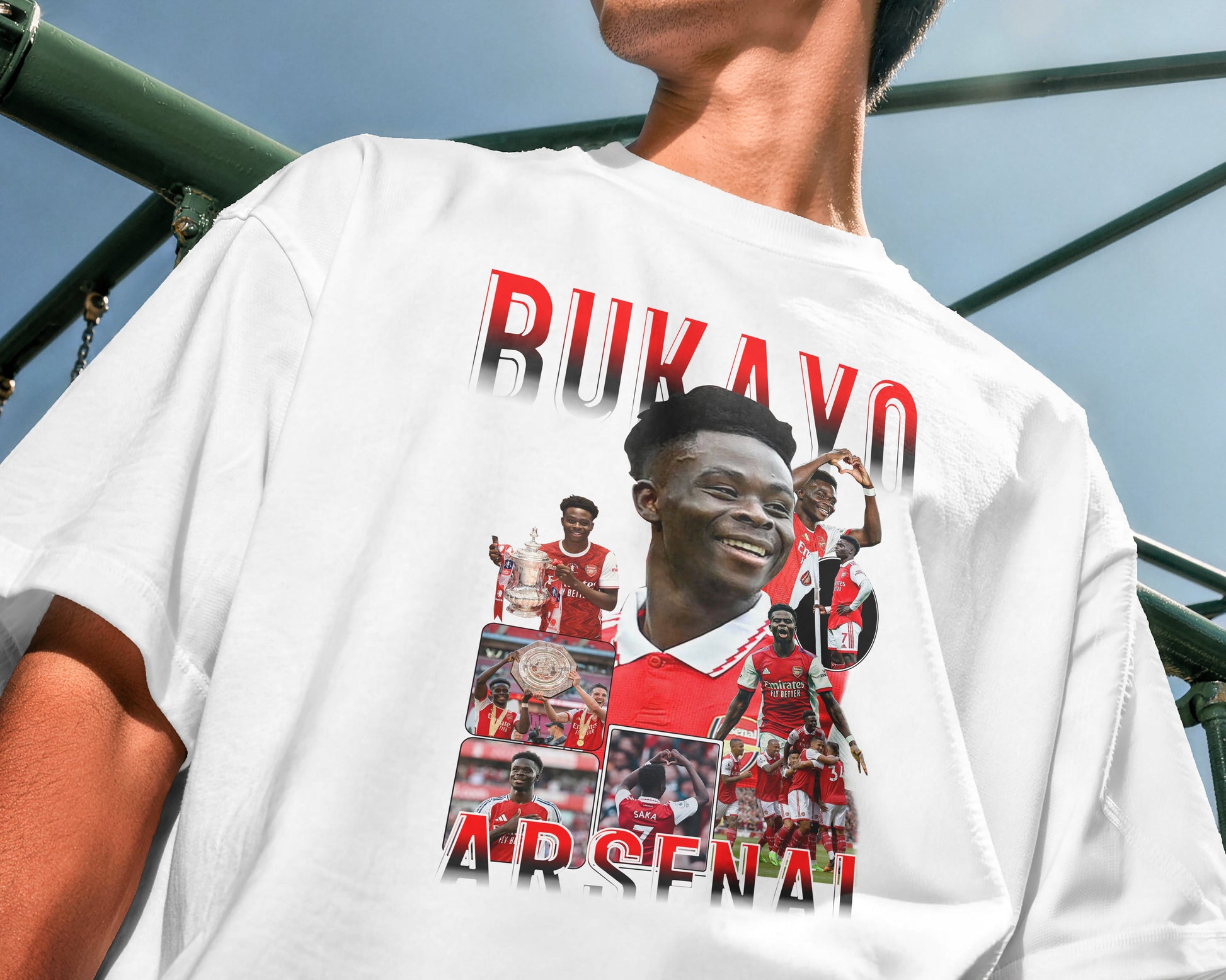 Person wearing a white t-shirt with a collage of images and text, standing outdoors.