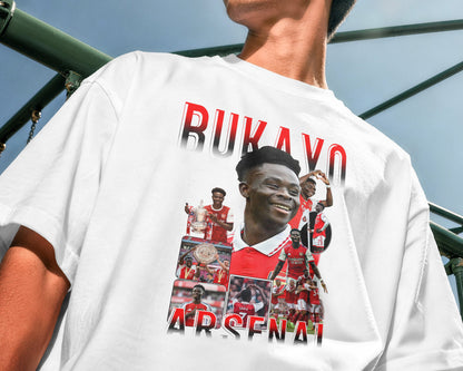 Person wearing a white t-shirt with a collage of images and text, standing outdoors.