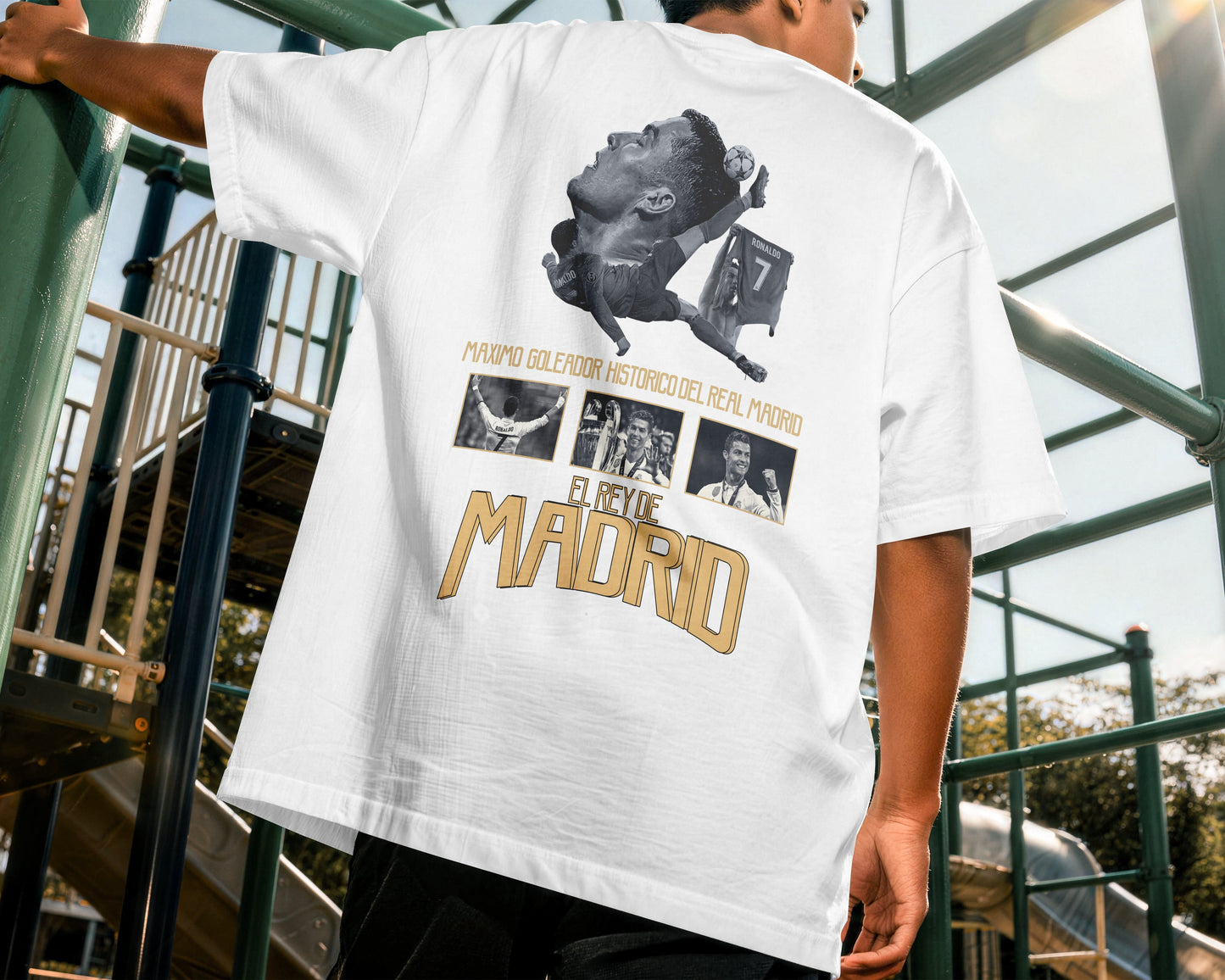 Person wearing a white t-shirt with graphic design and text, standing outdoors.