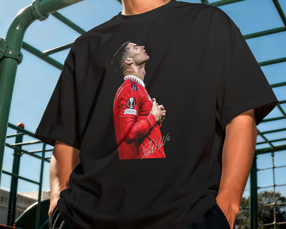 Person wearing a black t-shirt with a graphic design outdoors