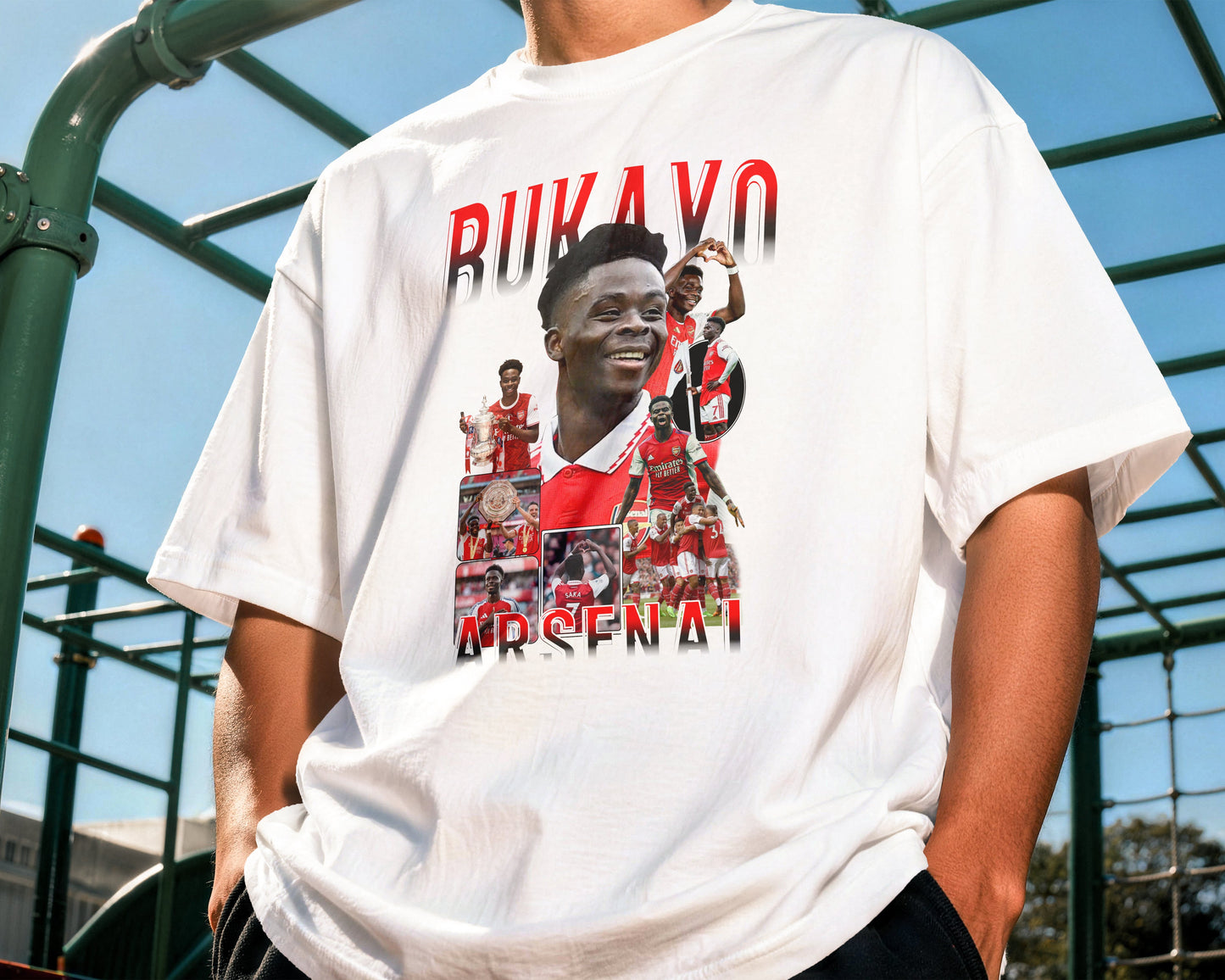 Person wearing a white t-shirt with a graphic design and text outdoors.