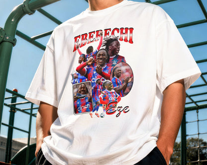 Person wearing a white t-shirt with a graphic design and text outdoors.