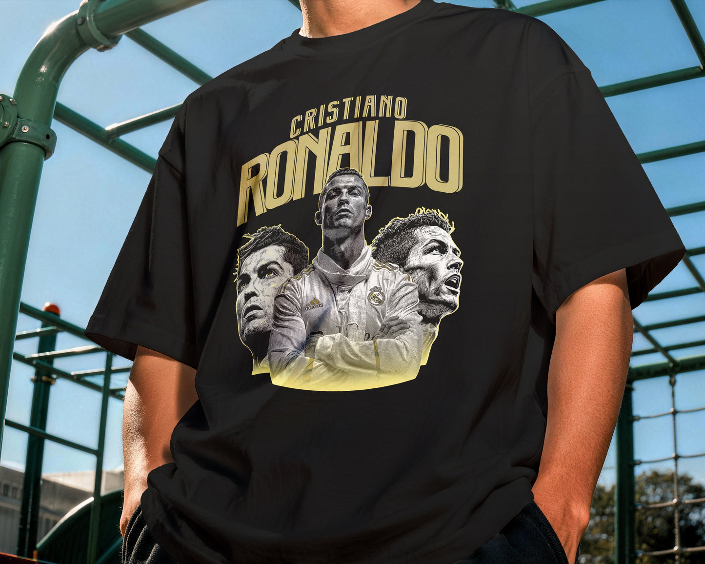 Person wearing a black t-shirt with 'Cristiano Ronaldo' graphic design outdoors.