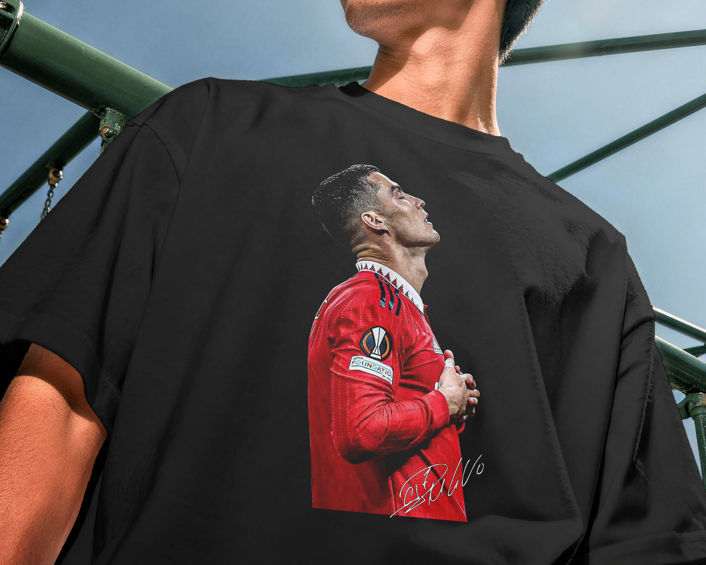 Person wearing a black t-shirt with a graphic of a person in a red sports jersey.