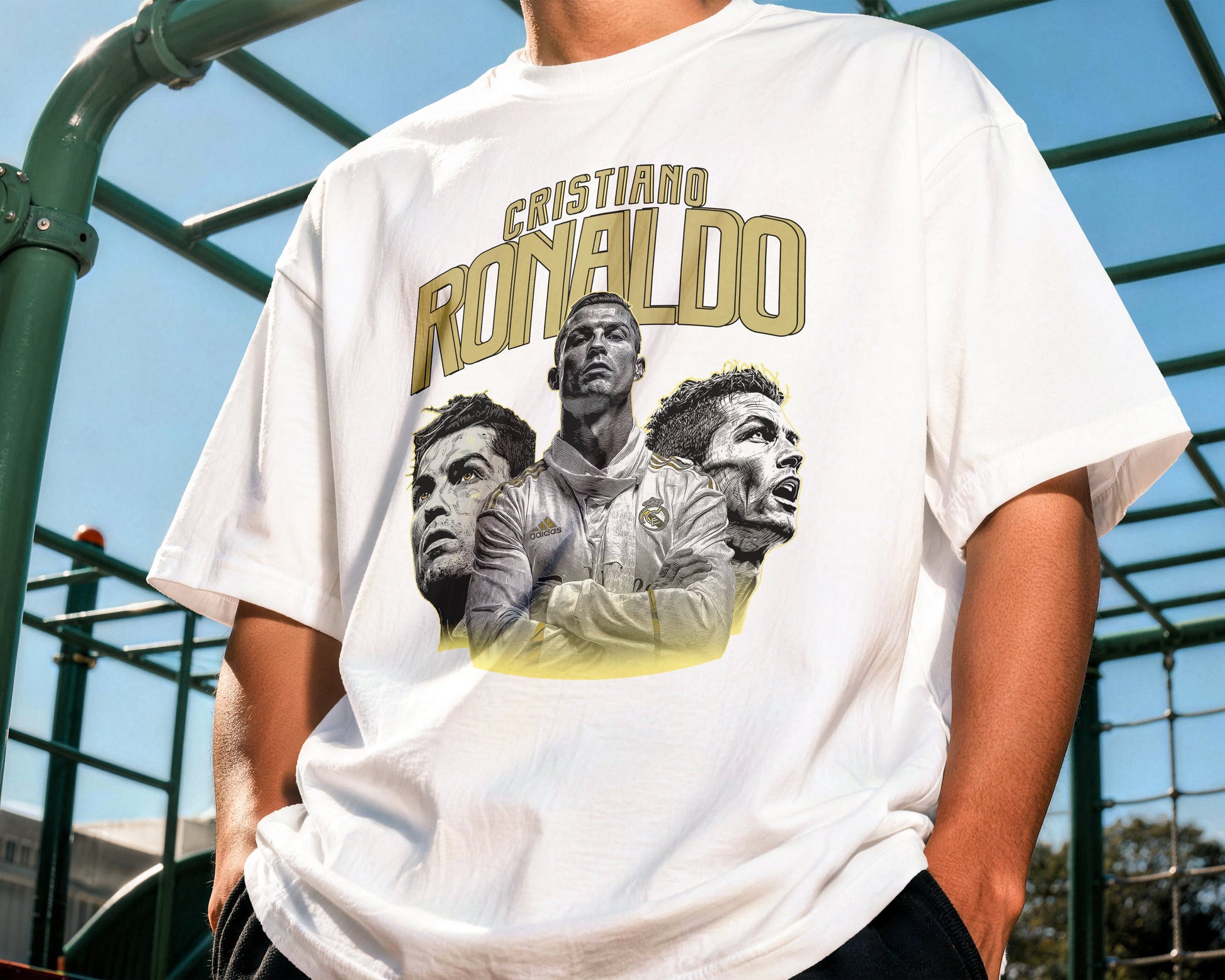 Person wearing a white t-shirt with a graphic of three men and the name 'Ronaldo' on it, standing outdoors.