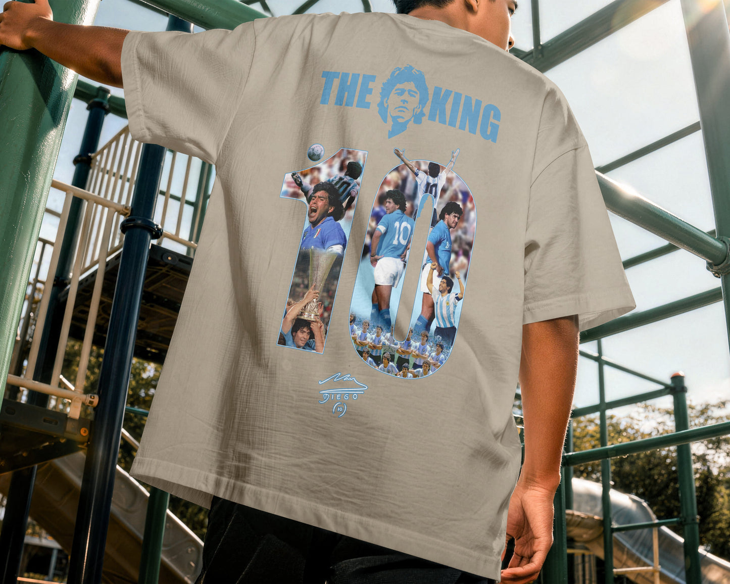 Person wearing a t-shirt with a graphic design on the back, standing in an outdoor setting.