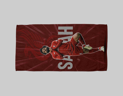 Red towel with a graphic of a person in a red outfit and 'SAH' text on a gray background